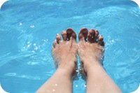 Female feet in pool water