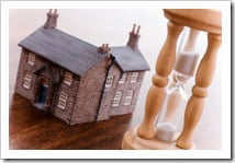 Hourglass and house real estate concept