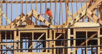 Un ouvrier du bâtiment examine une partie d'un bâtiment en construction